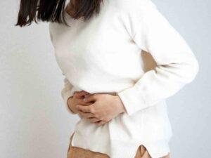 woman holding her stomach in pain