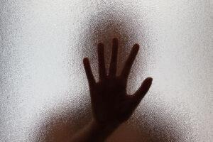 A hand of a human trafficking victim reaching out for help.