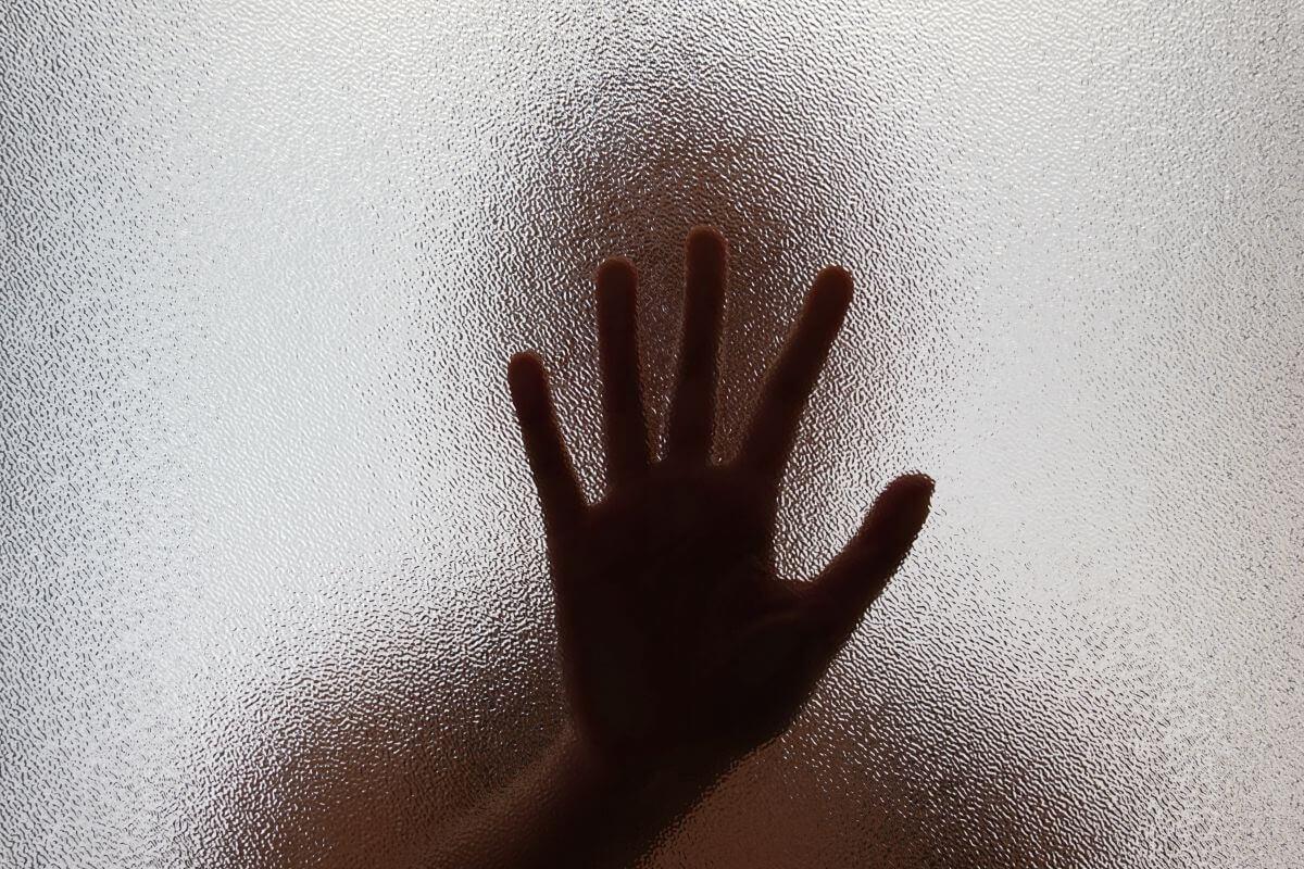 A hand of a human trafficking victim reaching out for help.