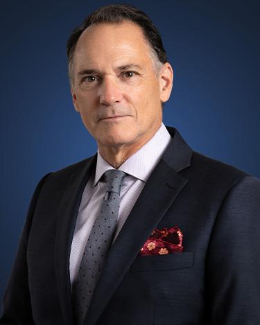 John Rarrick, wearing a dark suit with a red pocket square