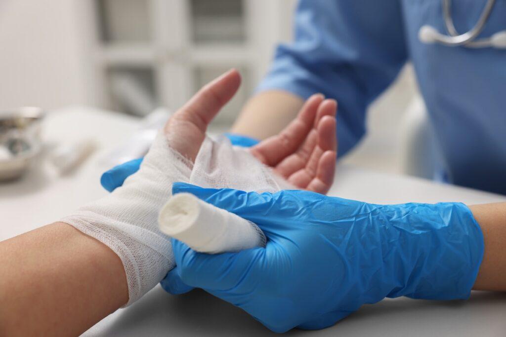 A burn patient being wrapped in bandages by a medical professional.