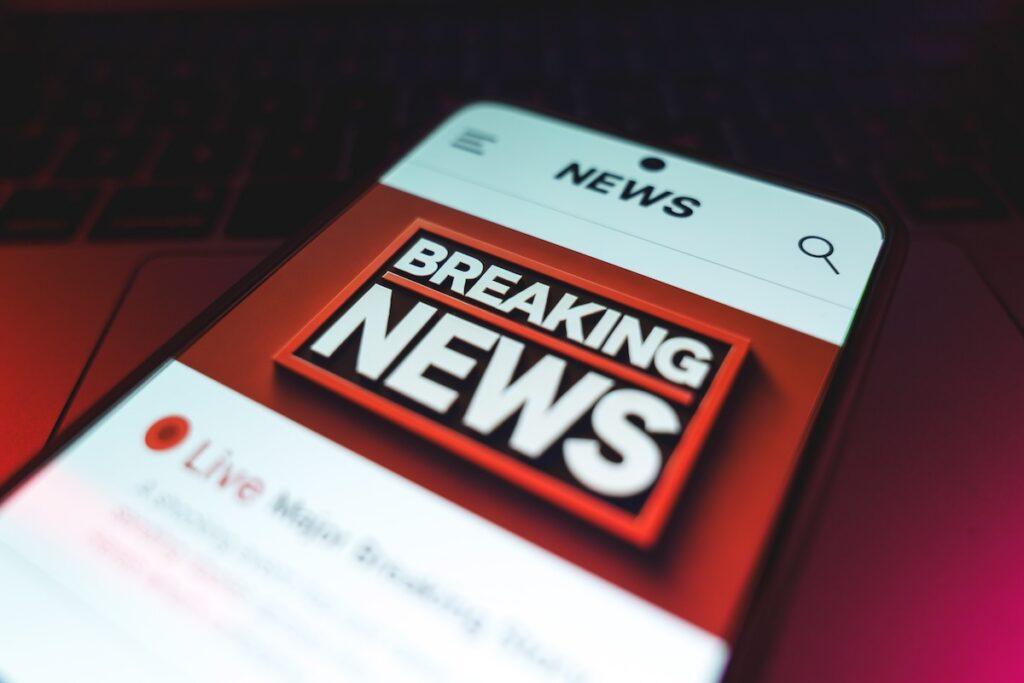 A breaking news headline shown on the screen of a mobile phone.