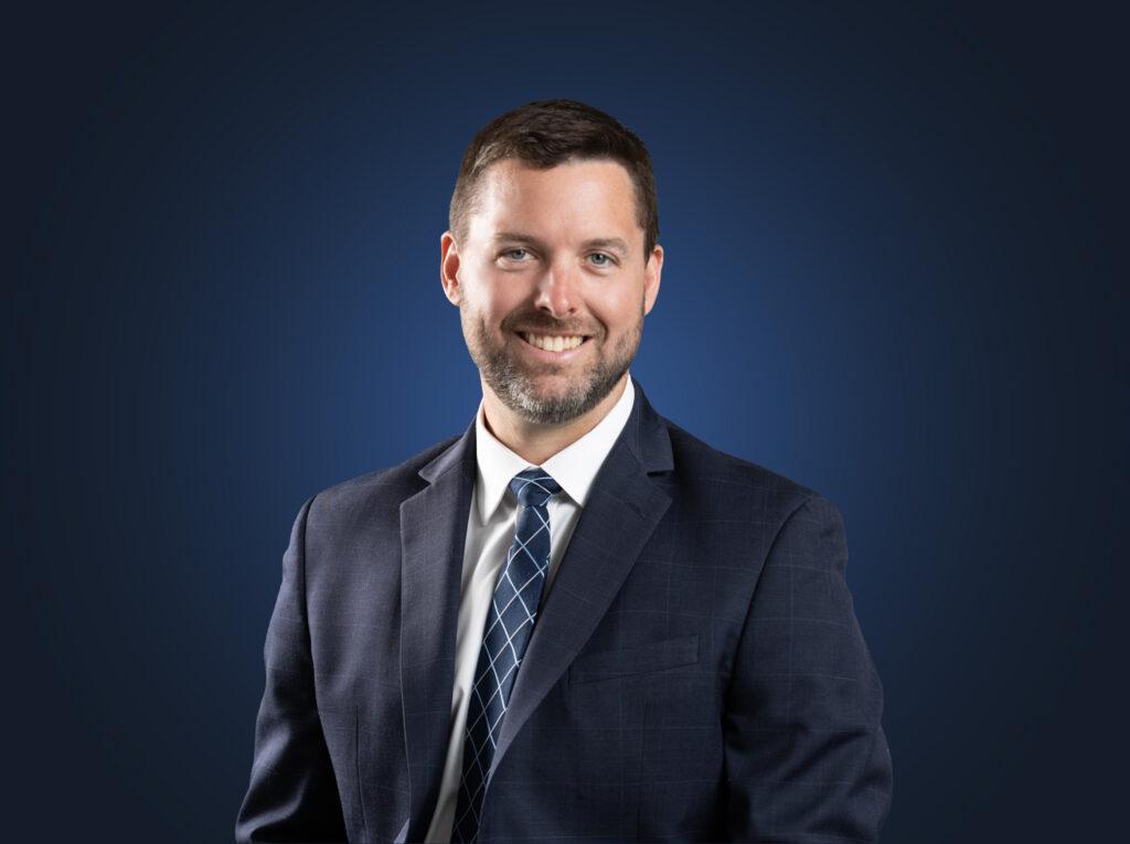 Attorney Michael Duffy wears a dark suit in front of a dark blue background
