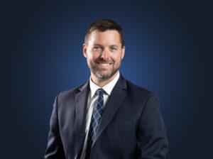 Attorney Michael Duffy wears a dark suit in front of a dark blue background
