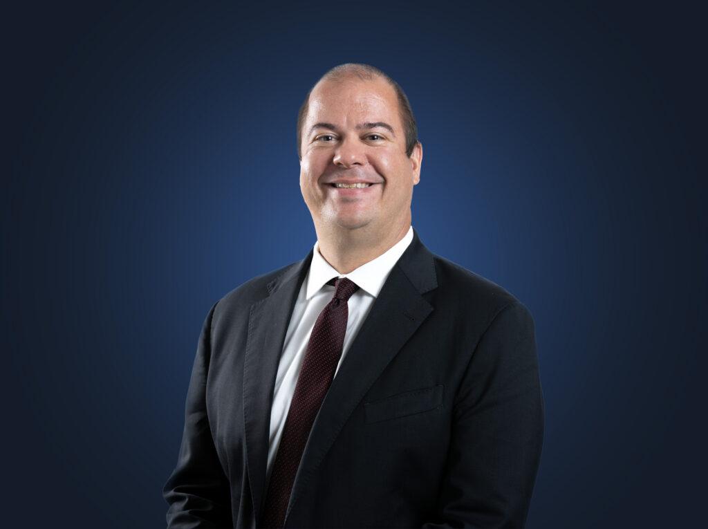 Attorney Andrew Shumlas in front of a dark blue background