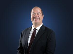 Attorney Andrew Shumlas in front of a dark blue background