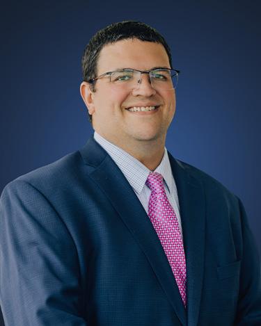Attorney Brian F. Dunstone, wearing a dark suit and a pink tie