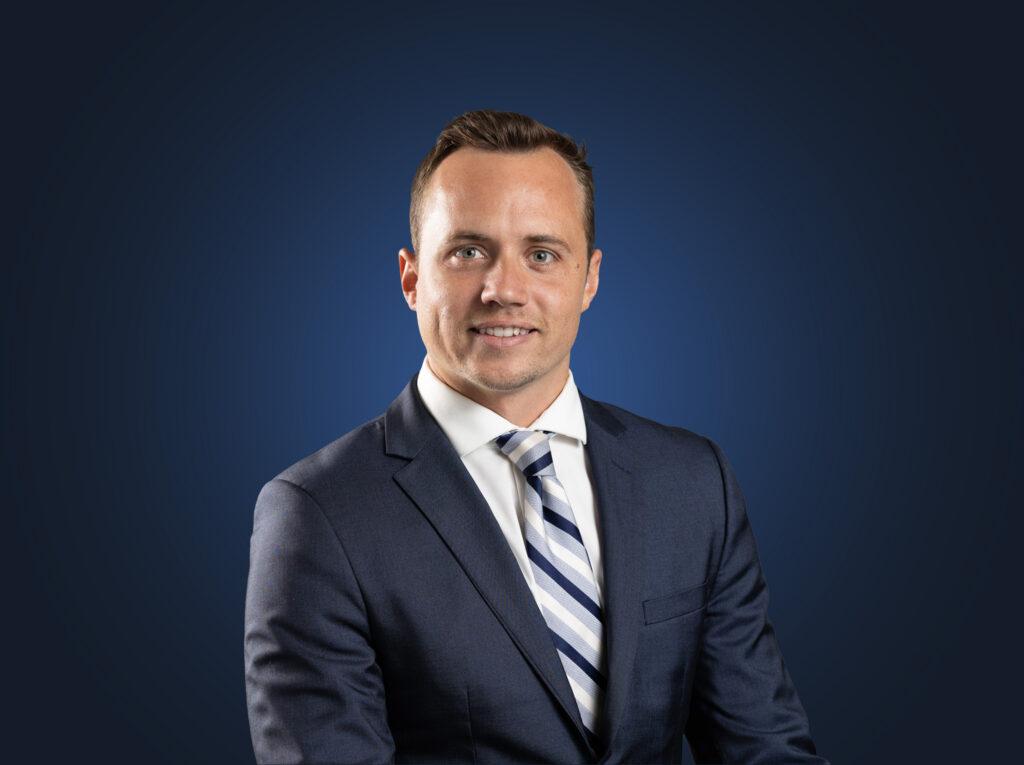 Attorney Kaio Carter stands in front of a dark blue background