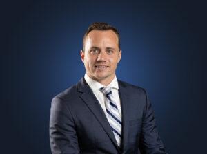 Attorney Kaio Carter stands in front of a dark blue background