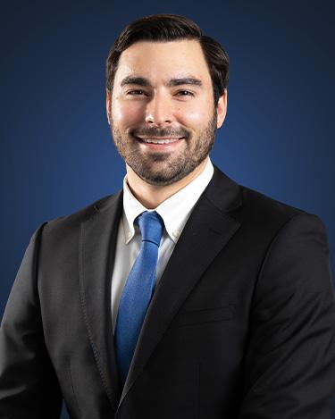 Anthony cirelli, wearing a dark suit in front of a dark blue background